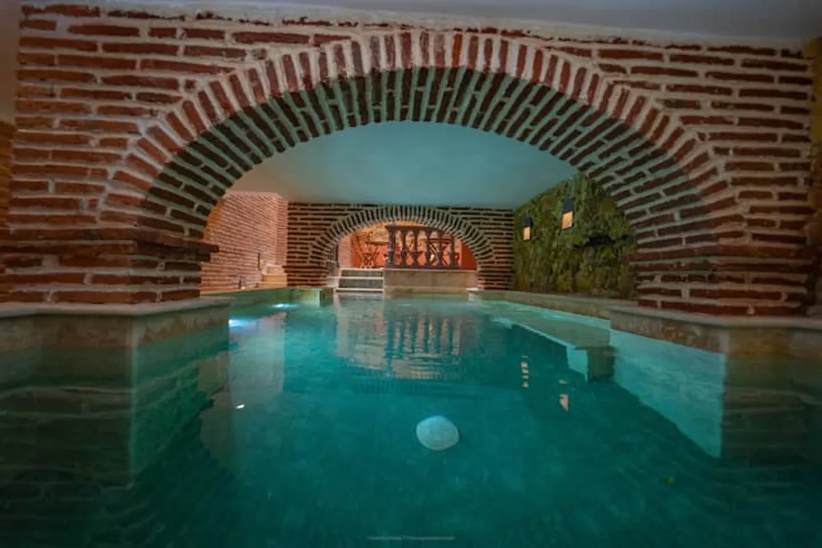 Vaulted brick pool lounge with turquoise water