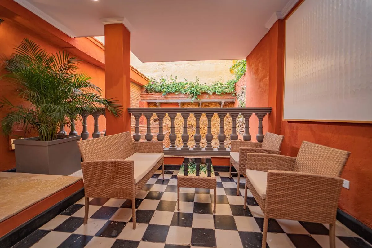 Checkerboard terrace with wicker seating and orange walls