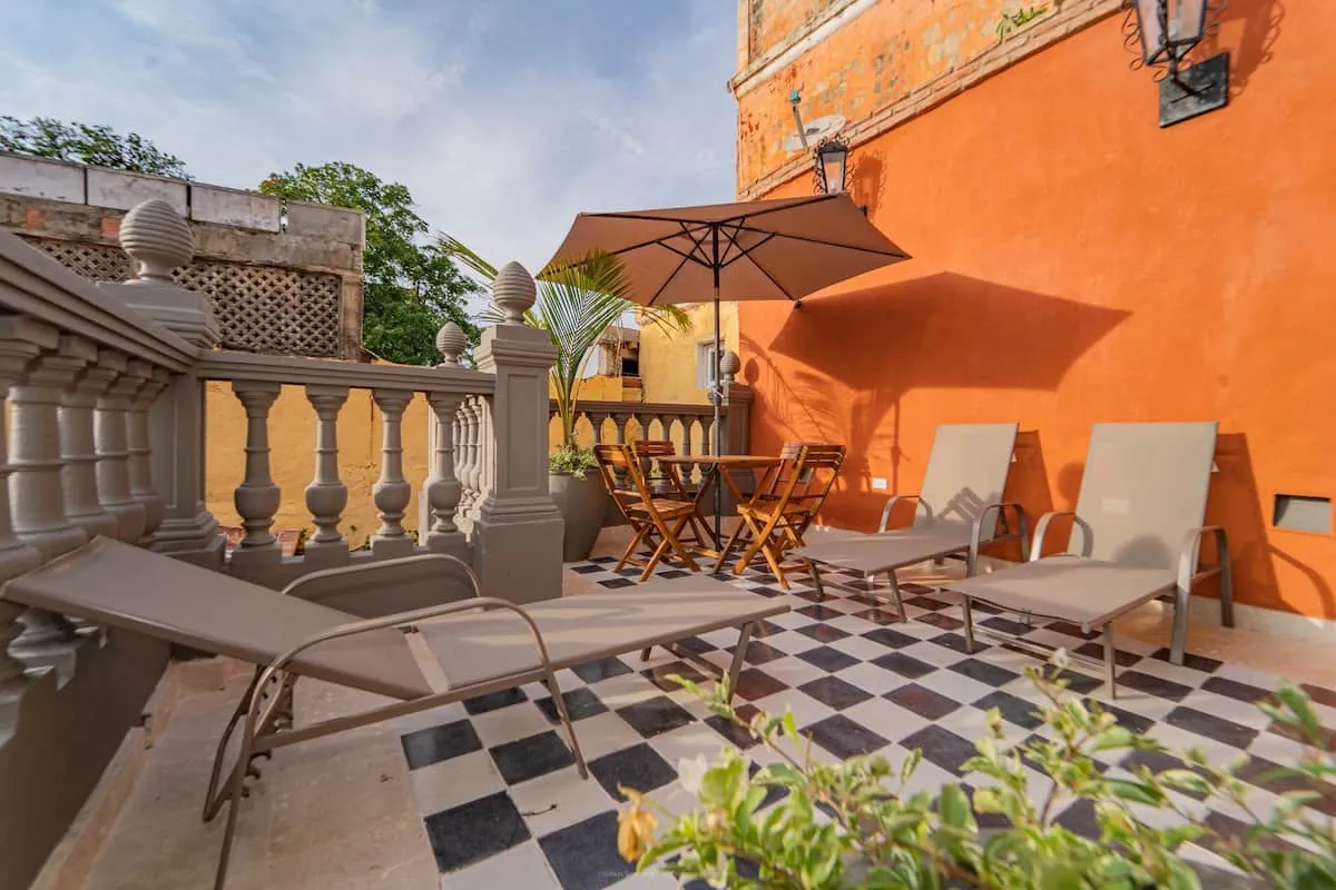 Rooftop terrace with loungers, umbrella, and dining table