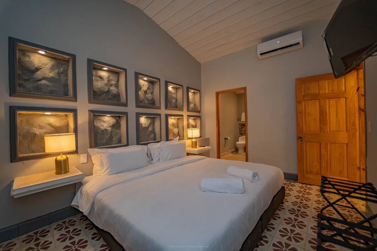 Bedroom with gallery wall, wood door, and patterned tile floor