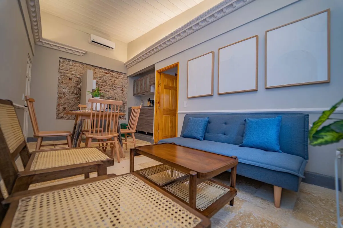 Suite lounge with blue sofa, rocking chairs, and dining nook