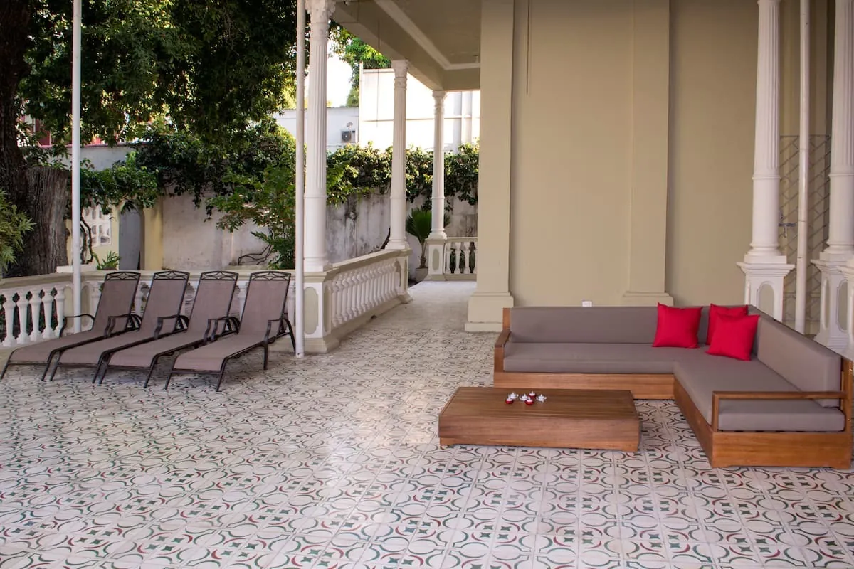 Veranda cubierta con asoleadoras, columnas y piso de mosaico