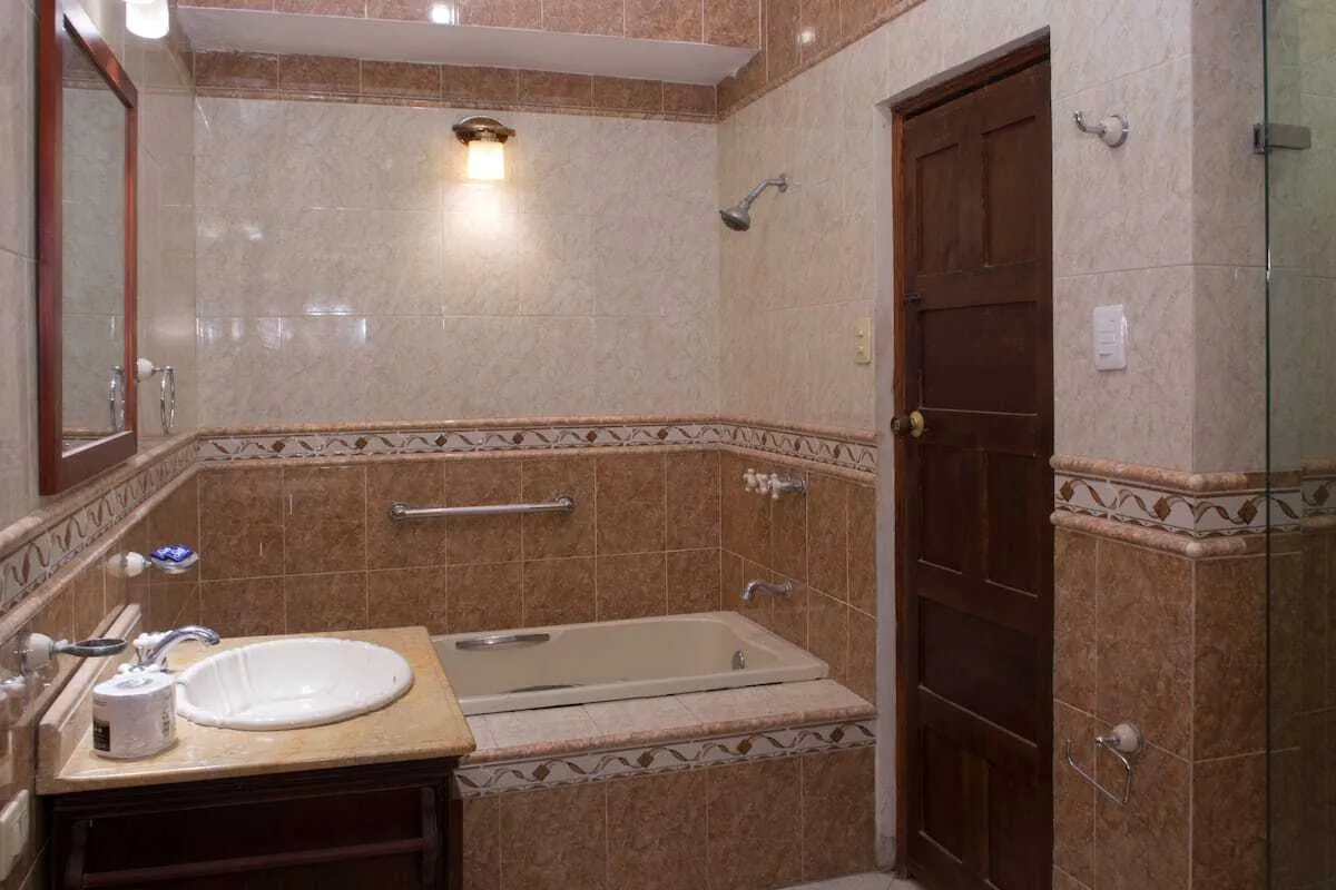 Bano enchapado con lavabo, espejo y zona de ducha
