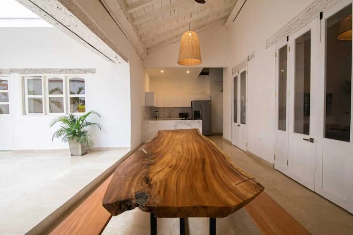 Mesa larga de madera natural junto al patio