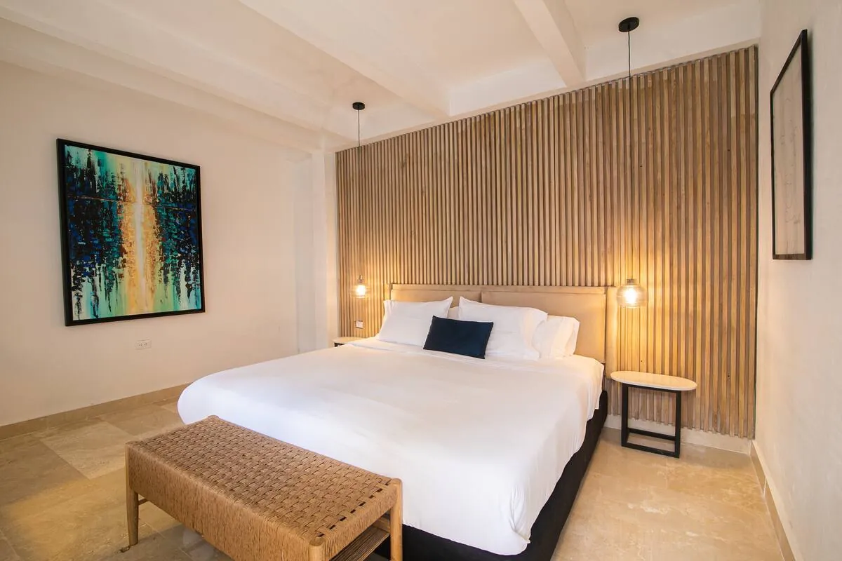 Habitacion king neutra con pared de listones de madera