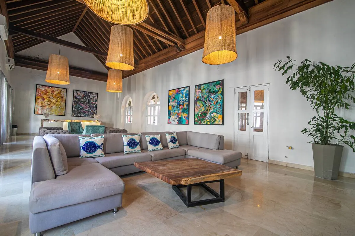 Spacious living room with timber ceiling, woven lamps, and sectional seating