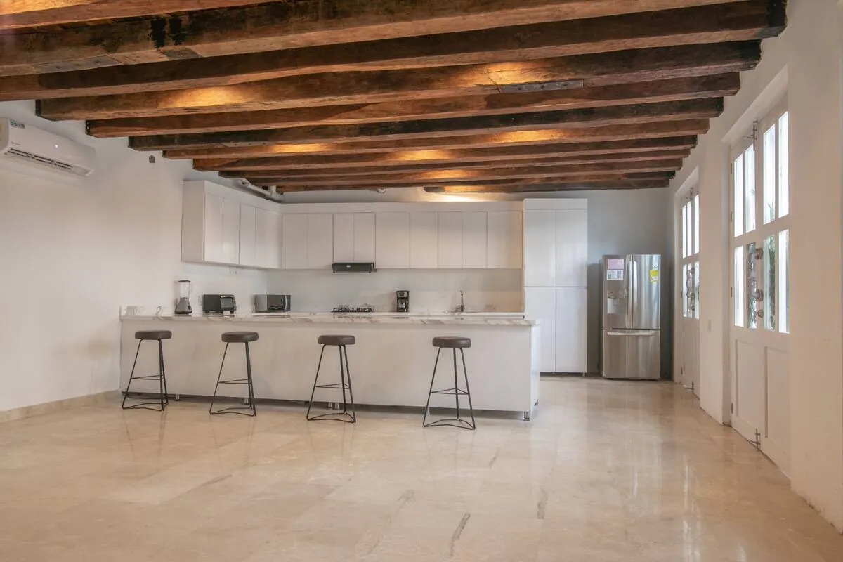 Open kitchen with long island, bar stools, and exposed beams