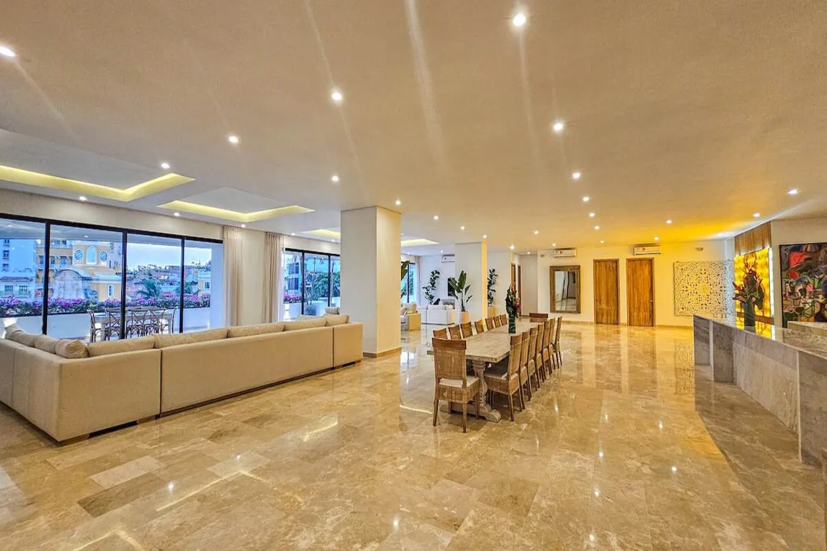 Open marble living, dining, and kitchen space with long seating areas