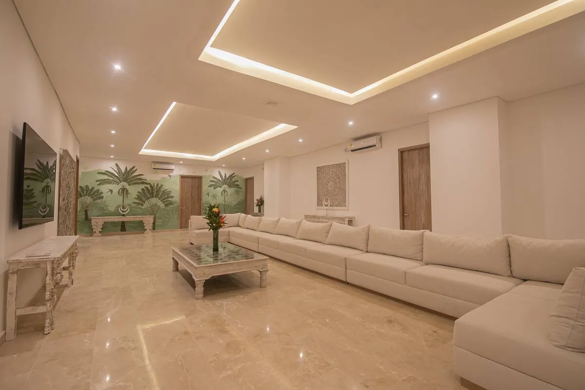 Long lounge with cream sofas, recessed lighting, and marble floors