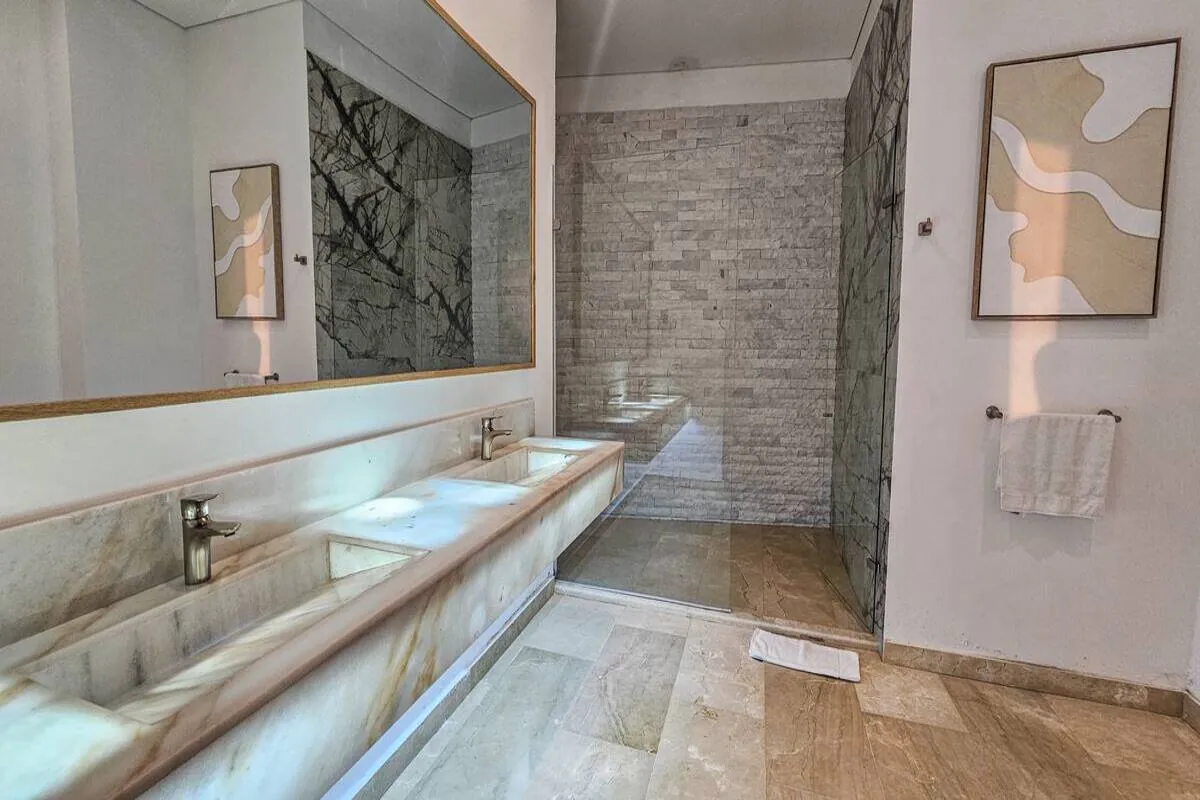 Large marble bathroom with double vanity and walk-in shower