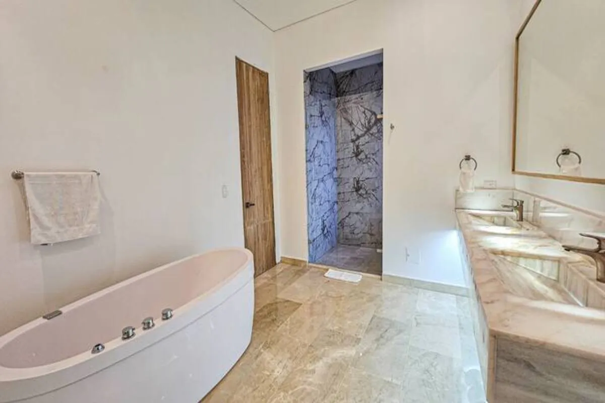 Marble bathroom with soaking tub, long vanity, and walk-in shower