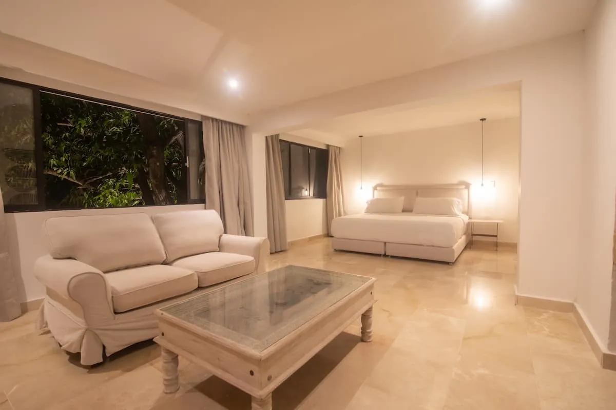 White lounge with sofas, glass coffee table, and pool terrace access