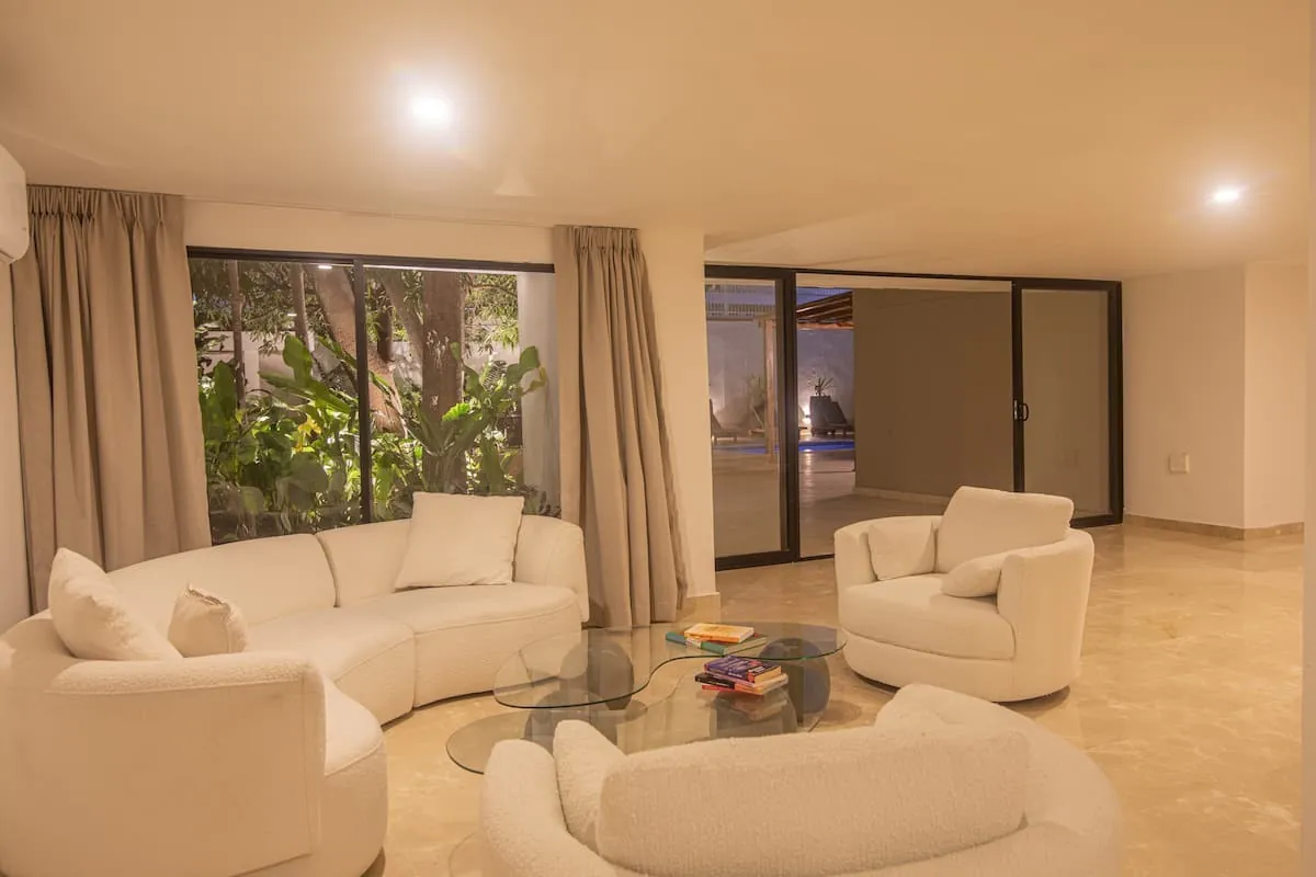 Comfortable living room with cream sofas and garden terrace access
