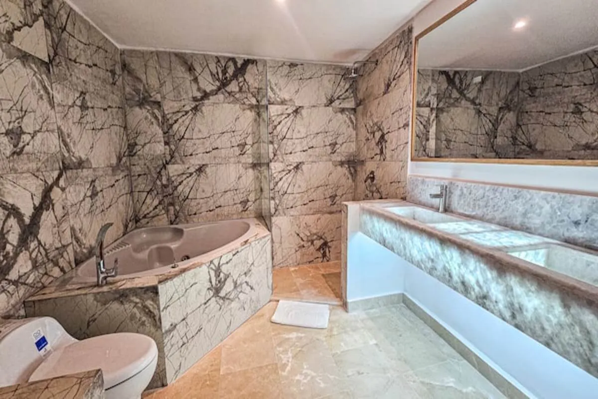 Marble bathroom with long vanity and walk-in rainfall shower